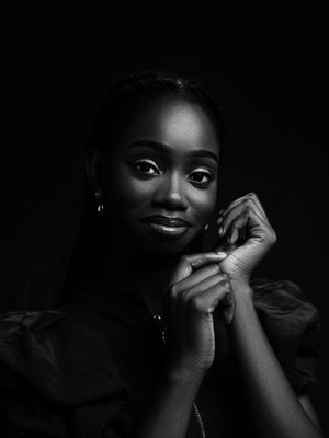 Elegant black and white portrait of a smiling woman with a graceful pose.